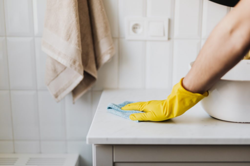 woman scrubbing bathroom counter