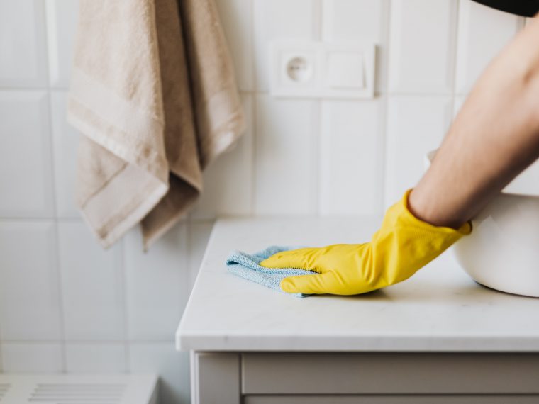 Photograph of woman cleaning counter.