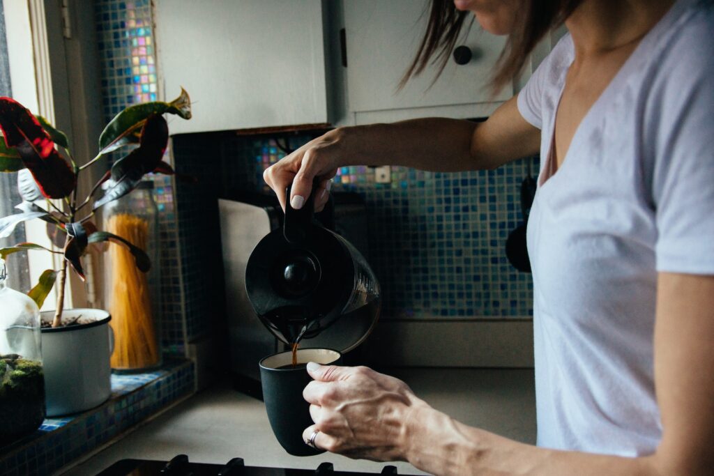 woman pouring coffee in cup.