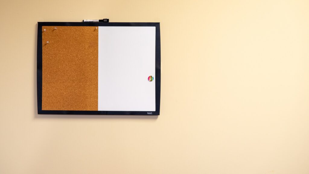 bulletin board with pushpins and magnets on a wall.