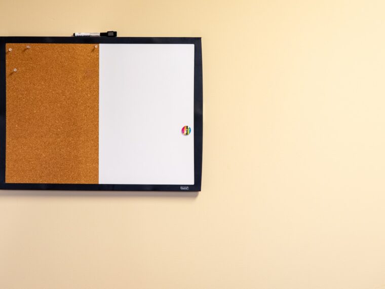bulletin board with pushpins and magnets on a wall.