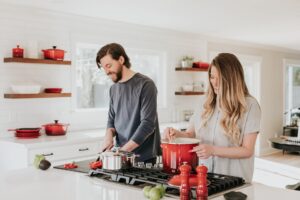 happy couple cooking in kitchen