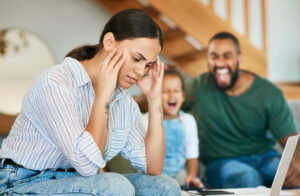 Stressed out mom holding her head.