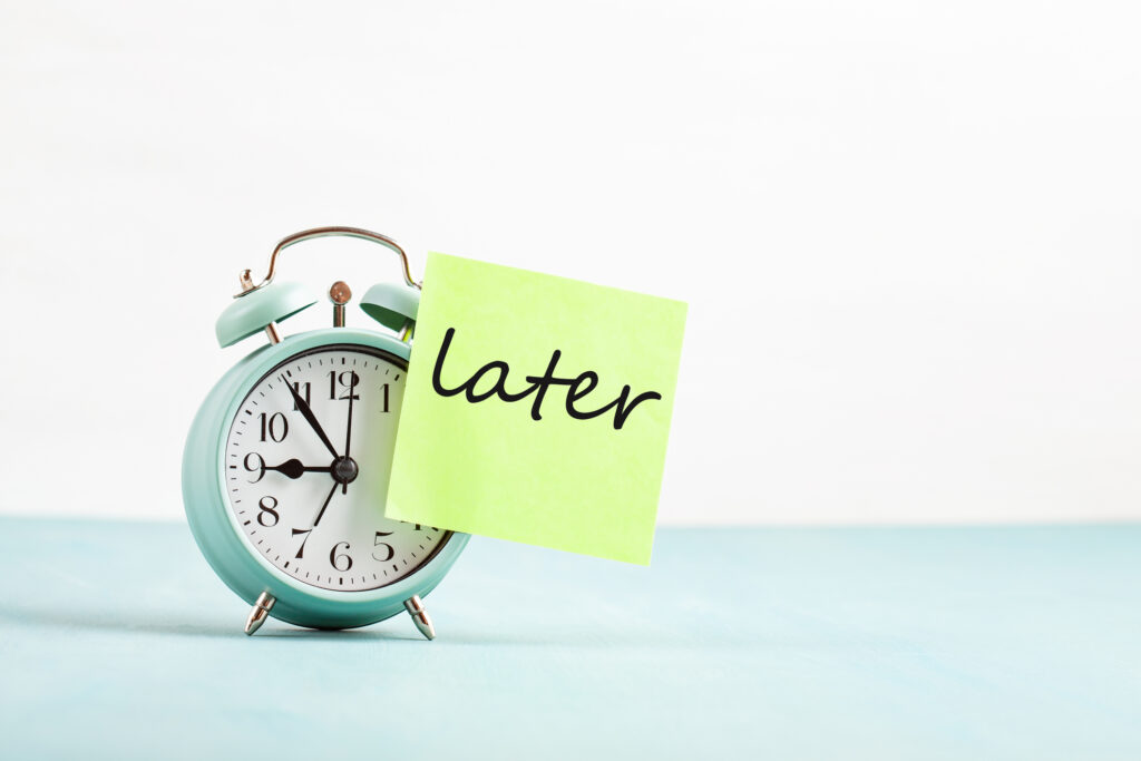 Clock with a sticky note that reads "later".