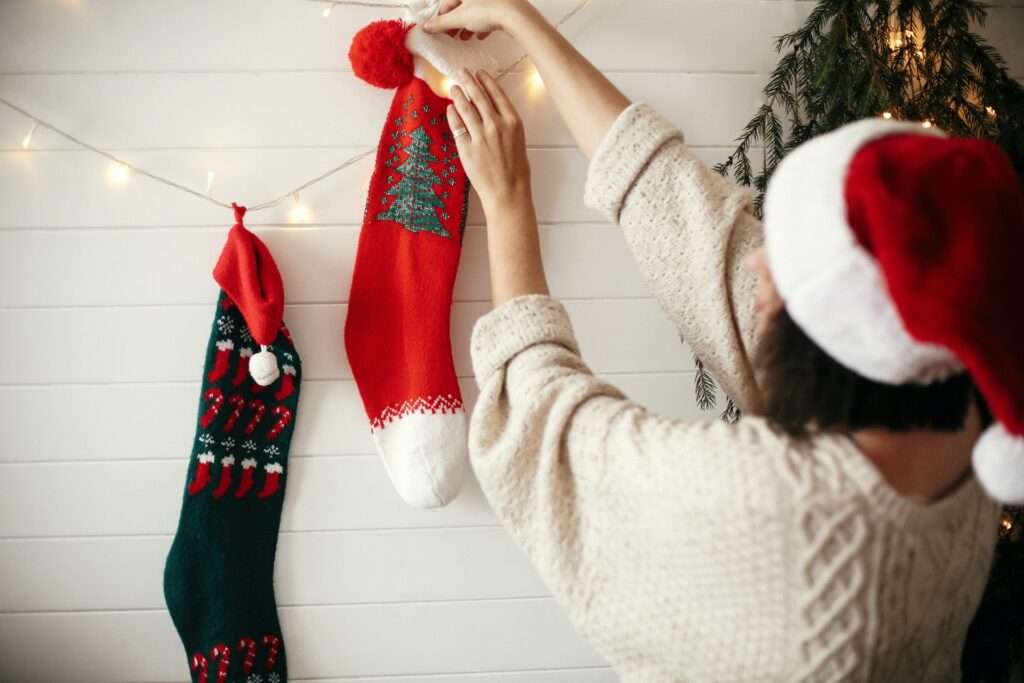 Woman hanging Christmas stockings.