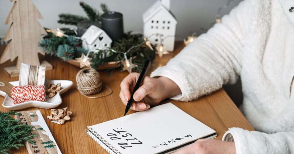 Woman planning Christmas writing in her to do list.