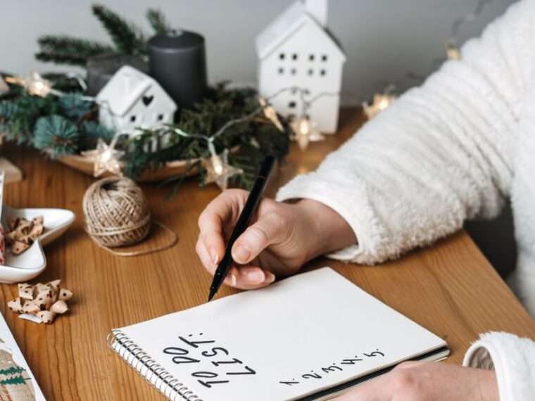 Woman planning Christmas writing in her to do list.